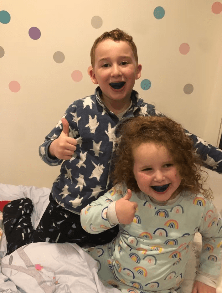 Two smiling children giving a thumbs-up